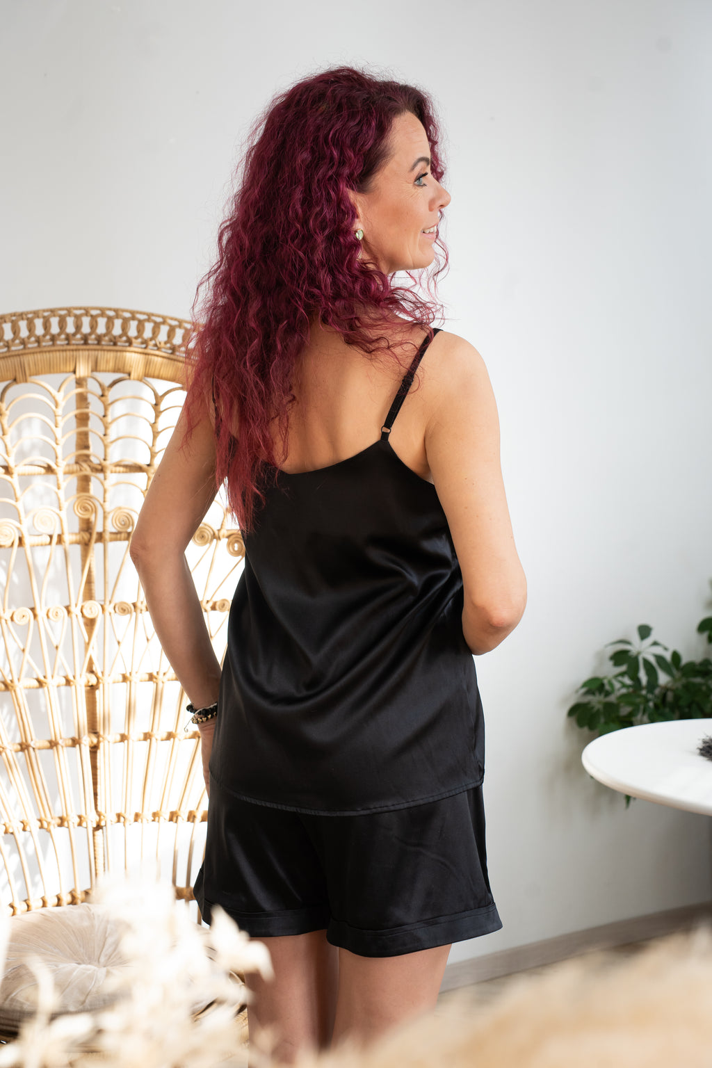 Woman wearing a black leisure set made of silk.