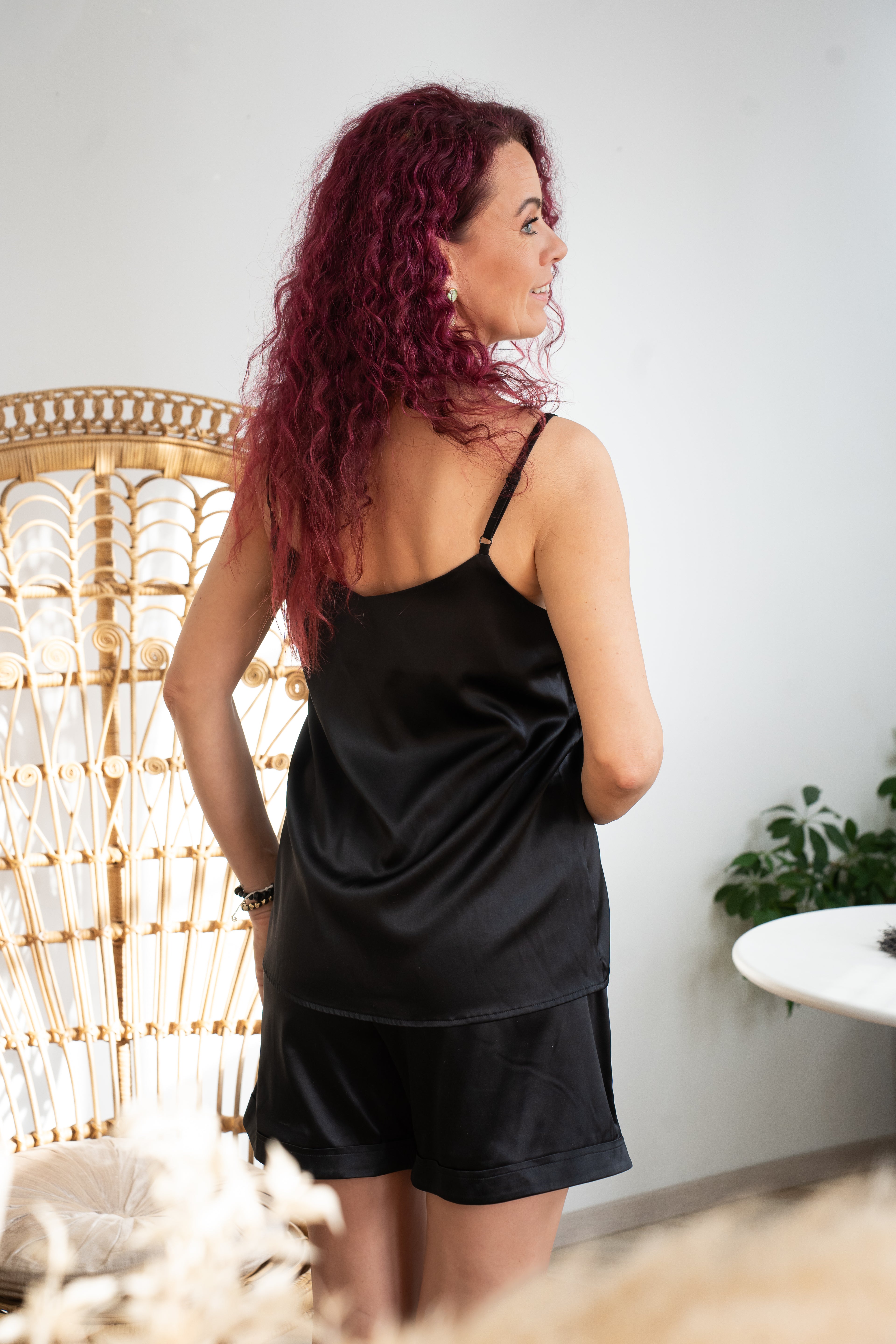 Woman wearing a black leisure set made of silk.
