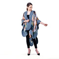 A woman modeling a blue-gray open-front poncho with a multicolor abstract print, worn over a black top and black leggings against a plain white background.